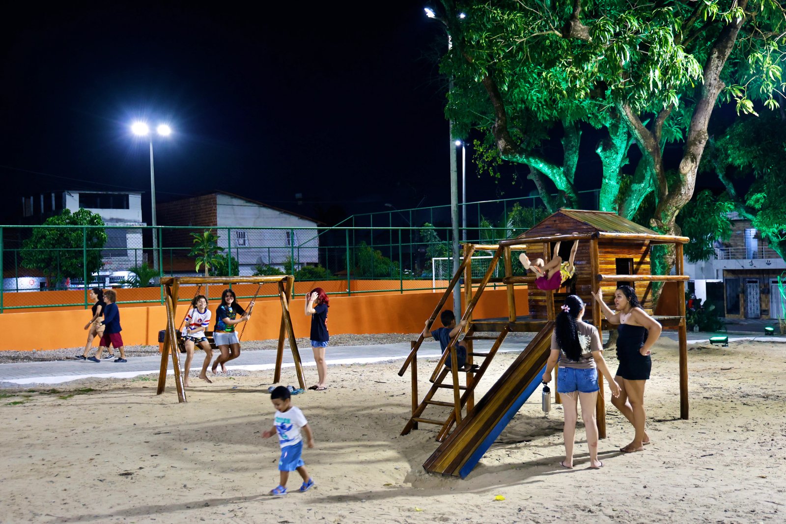 Crianças brincando nos brinquedos do parquinho da Praça